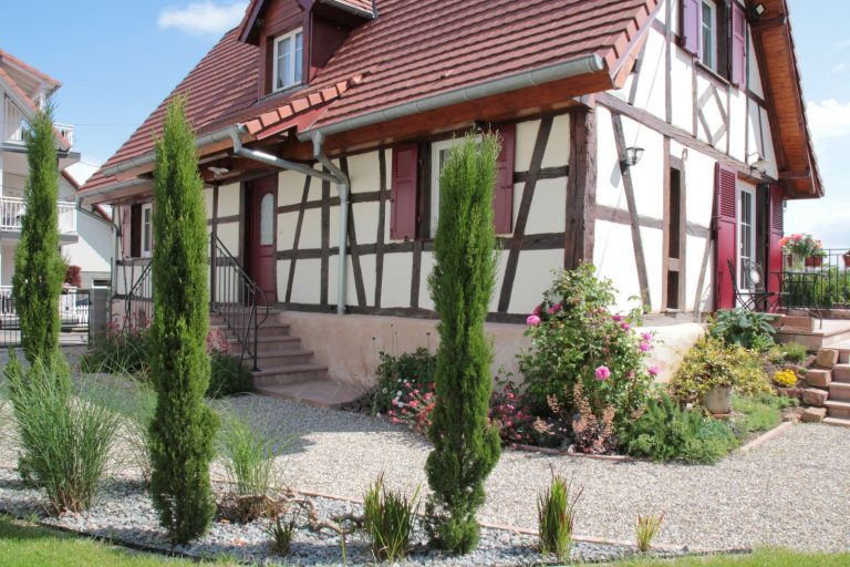 Le jardin à ses début et la maison alsacienne à colombages du gîte d'Anny et Jean Yves