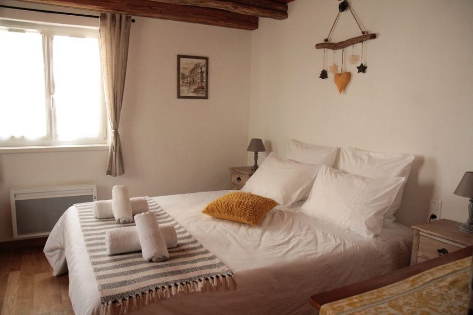La chambre du rez-de chaussée joliment décorée avec un grand lit confortable