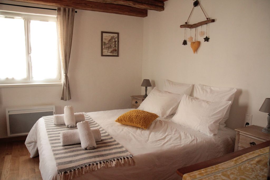 La chambre du rez-de chaussée joliment décorée avec un grand lit confortable