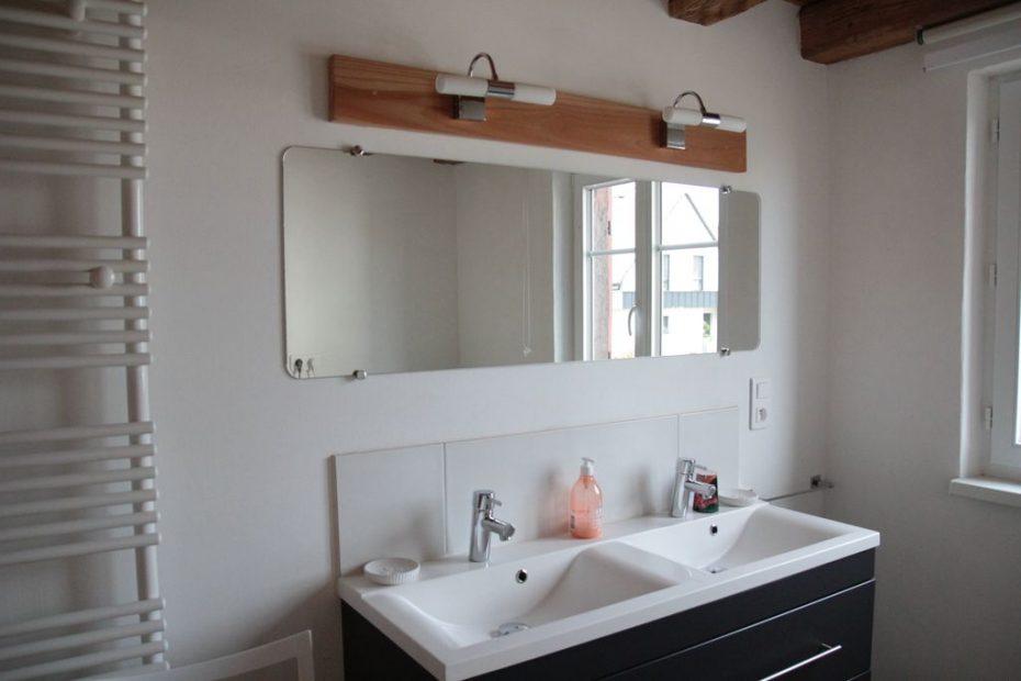Salle d'eau du rez-de-chaussée avec deux lavabos et un miroir, offrant un espace fonctionnel et élégant.